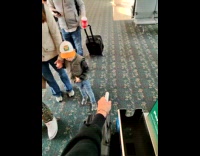 Kid blocks man luggage getting in line