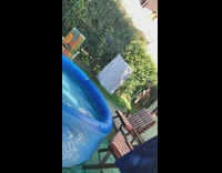 Guy runs jumps in blue inflatable pool 