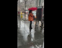 Girl filming tik tok in rain on street