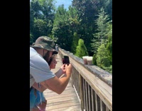 Man and Woman pictures their coffee at the bridge