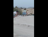 Girl throw sand on bottle beach windy