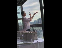 Guy keeps filming his hand with view of city 