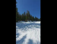 Skiier Does Snow Jump then Falls Backwards