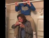 guy blue shirt on top of guys shoulders giving him beer