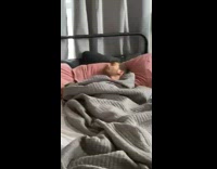 Guy sleeping through multiple alarms in bed 