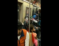 Two guys in Joke and the Saw makeup sit on subway train