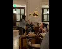 Two girls pose with their drinks inside bar