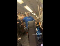Guy in blue shirt with rabbit hat on singing on subway