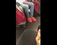 Guy wears orange furry slippers on the subway