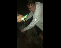 Guy in white jacket does keg stand at party in front of friends