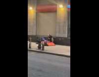 Man sit on street sing karaoke speakers