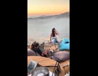 Collab IITW - Woman sits on railing edge for photo mountain sunset background