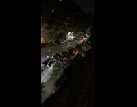 Man sets off fireworks in the middle of the street as cars approach