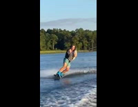 Guy holds dog while wakeboarding 
