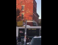 Pink sweater guy sits white bus roof