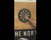 Dart almost hits hand grey shirt guy 
