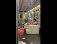 Three guys sit on white couch on train