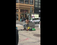 Guy sitting on chair plays violin sidewalk 