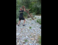 Man lifts and moves a log on the other side