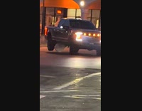 Truck drags huge rock underneath it on parking lot