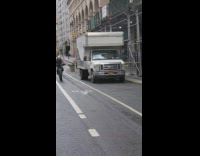 Guy riding bicycle wears brown alien mask 