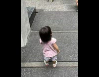 Baby walks and tries to jump like the person in front