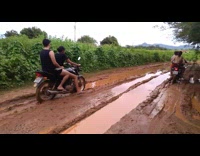 Motorcycle with one guy two girls tips over in flooded mud road and falls into muddy water