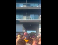Two kids on balcony near a concert