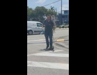 Man rides skateboard with his pet iguana