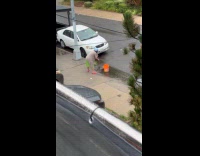 Collab WINY - Woman fill bucket with flood water from gutter