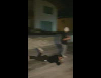 Two guys slide on icy road for video and one slips