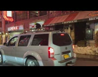 Guy stand over car snow pile night