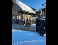 Person fur coat films beside ski bar