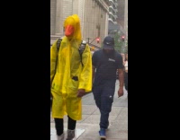 Collab WINY - Man wear yellow raincoat and duck mask with man in black shirt behind