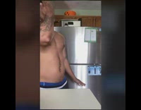 shirtless guy snorts checks refrigerator 