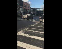 White scooter with flat tire drives on sidewalk