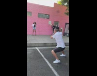 Guy photographs black shirt girl pink wall 