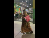 Guy wearing large brown furry coat on street