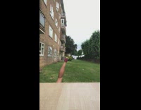 Woman in Nike shorts does bottle cap challenge, kicks bottle over and falls down on grass