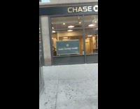 Black face mask guy sidewalk green bag