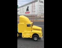 3 guys sit in small yellow truck 