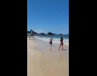 Bald man grey shirt thumbs up beach