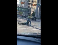 Lady in green stands in street  on top of photographer for photos 