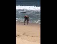Man shake down shorts to remove sand