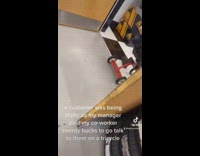 Guy comes out of office in small red tricycle to talk to customer