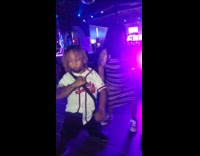 Man and woman with dwarfism dance together at night club 