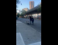 Man riding bike tries to push cart