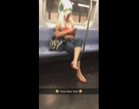 Woman wears giant tall white wig on the subway uses phone