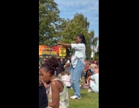Woman white top dances at Caribbean festival