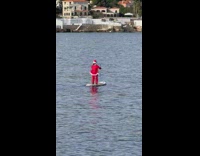 Person santa costume paddle on board beach
